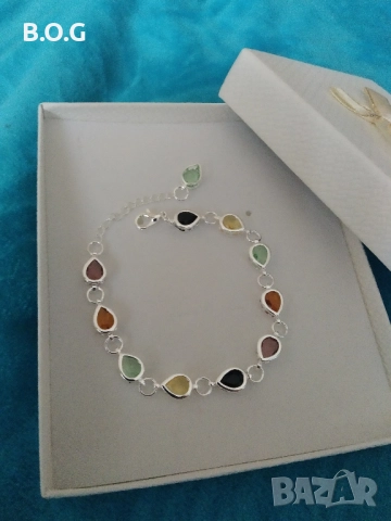 Нова, сребърна масивна гривна с разноцветни кристали. В кутия за подарък.