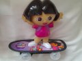 Детска играчка ДОРА НА СКЕЙБОРД с батерии, движи се, пее и свети, снимка 1 - Кукли - 38964652