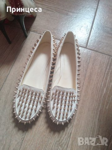 Бели мокасини със златисти шипове.
