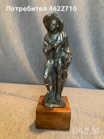 стара калаена статуя  на човек  с шапка върху дървена основа