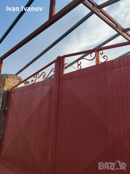 масивна метална врата с декоративни орнаменти и горна конструкция, снимка 1