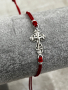 Гривна червен конец със сребърна фигура кръст с разпятие