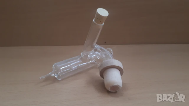 Стъклена тапа за бутилки, която изглежда като спринцовка